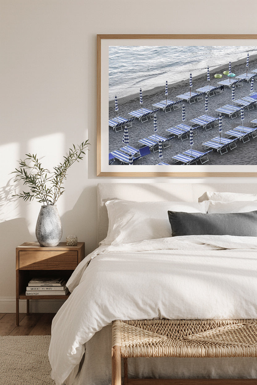 Minimalist fine art print of the Amalfi Coast, Italy, with rows of empty blue striped umbrellas and sun loungers on the beach, serene coastal Mediterranean photography.
