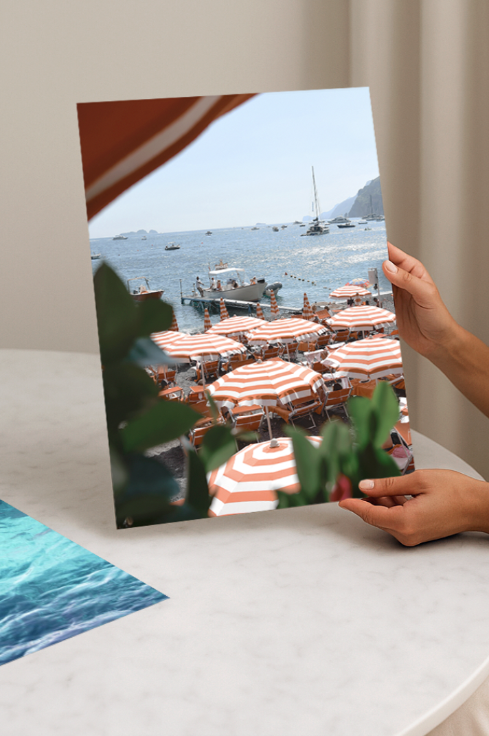 Positano Italy coastal wall art print featuring iconic orange beach umbrellas. A timeless travel photography piece for elegant home décor and interiors.