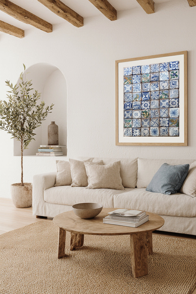 Living room with a beige sofa, wooden coffee table, and wall art print of intricate blue Italian tiles from Capri, Italy.