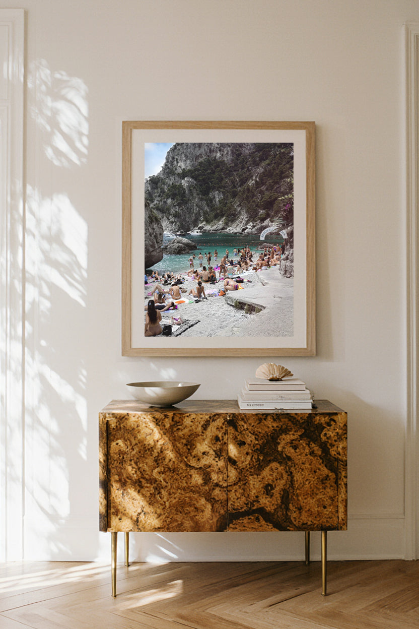 Framed beach photograph above a decorative console table in a minimalist interior, luxury home décor.