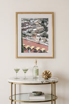 Framed Amalfi coast travel photography print of Positano’s rooftops, styled  above a marble bar cart.