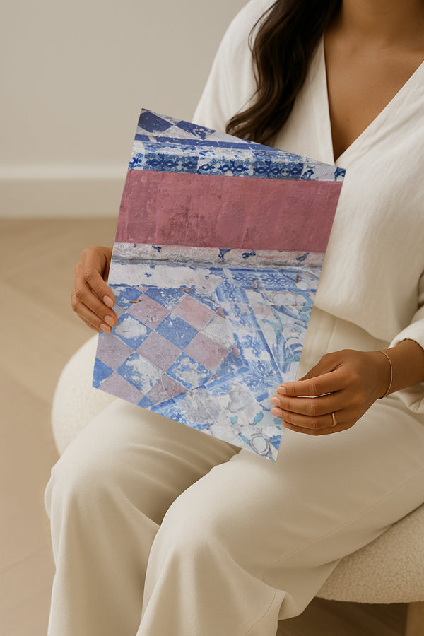 Woman holding a fine art photography print of vintage blue and pink Mediterranean tiles, captured in Seville, Spain. Stylish wall art print perfect for coastal-inspired interiors.